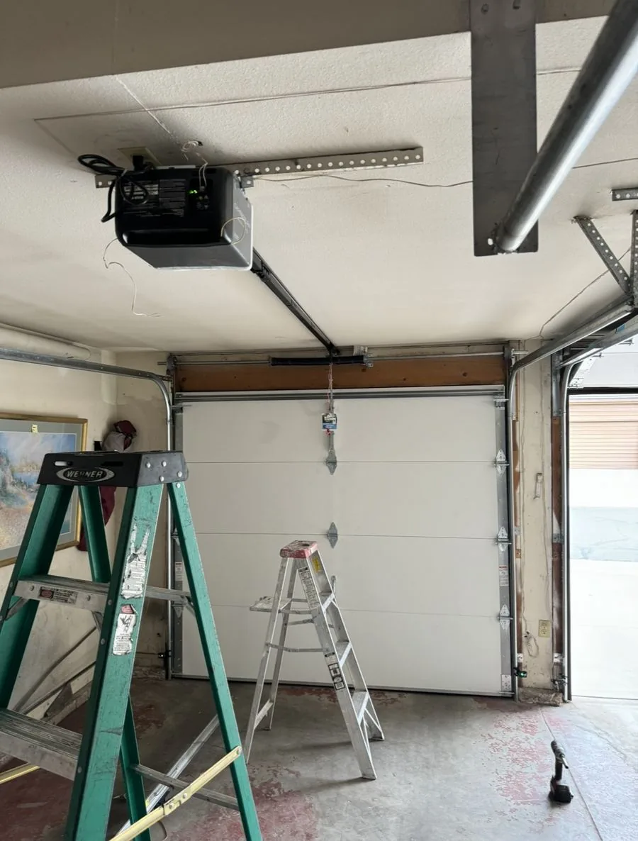 Torsion spring and opener rail over a garage door